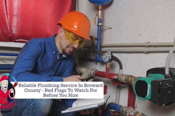 plumber wearing a hardhat and goggles working on pipes