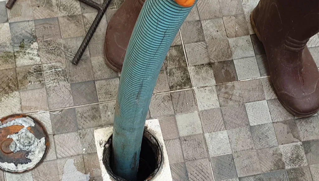 plumbing professional using device on a drain